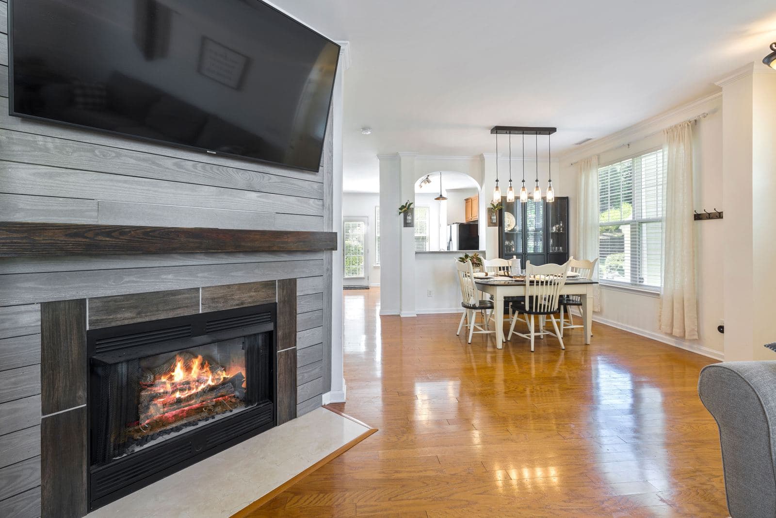Bright living and dining area with a fireplace, viewed from the seat where the TV would be watched